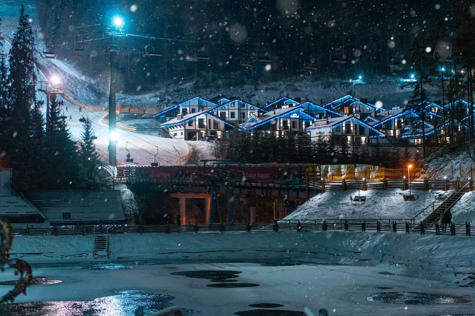 Village de montagne sous la neige en soirée, toitures chargées